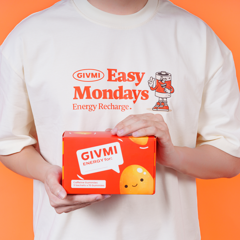 Person holding a GIVMI ENERGY box of sugar-free caffeine gummies, perfect for energy recharge and boosting focus on busy Mondays.